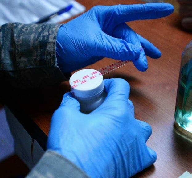 hand with gloves that is mixing a bottle