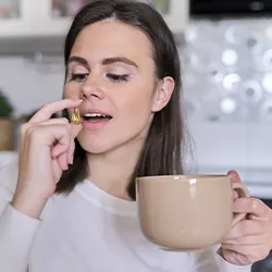 woman placing a pill inside her mouth