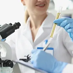 A woman holding a test tube filled with urine in a laboratory