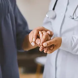 A doctor checking a person's fingernails